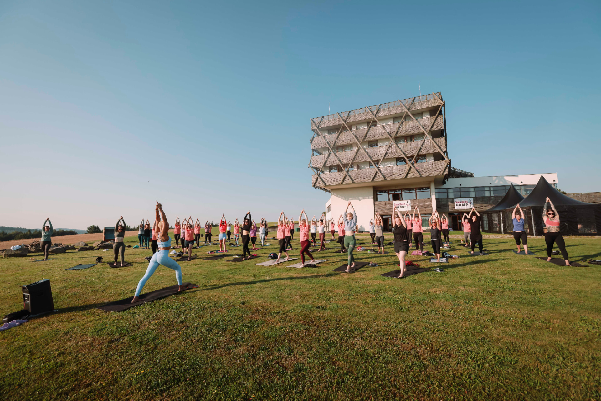 Gemeinsames Outdoor-Workout auf der Wiese vor dem Camp-Hotel